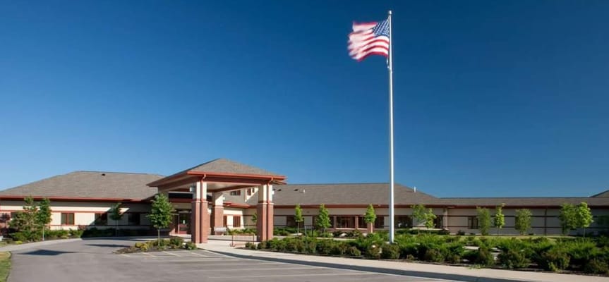 Front entrance of Badger Prairie Health Care Center with American flag