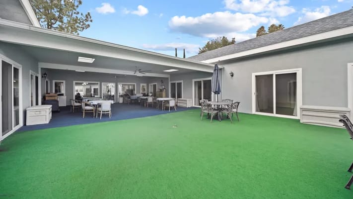 Outdoor patio area with seating and green lawn