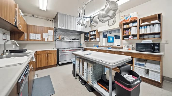 Interior kitchen area with cooking equipment and storage