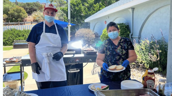 Staff grilling outdoors with residents' meals being prepared