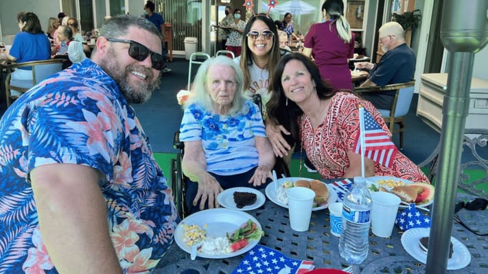 Residents and staff enjoying a meal together outdoors