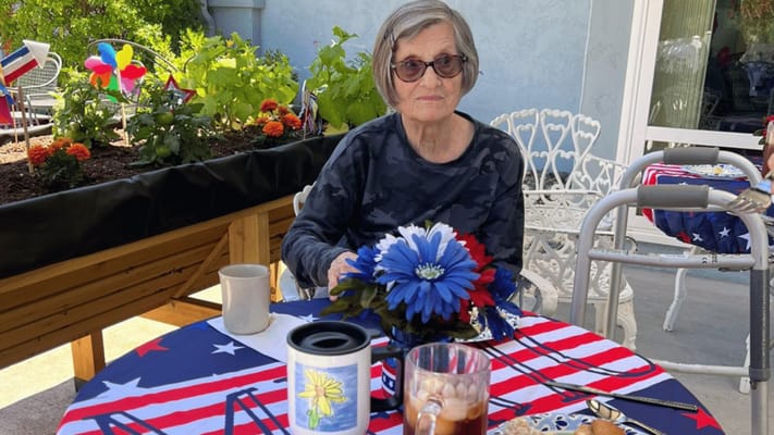 Resident enjoying a meal outdoors with patriotic decor