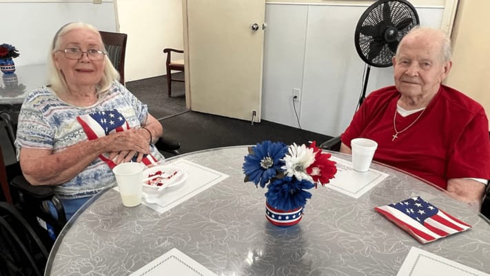 Two residents enjoying snacks at a table with decorations