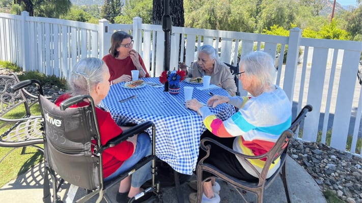 Residents enjoying lunch outdoors at a table