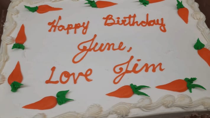 A birthday cake decorated with orange carrots and a message