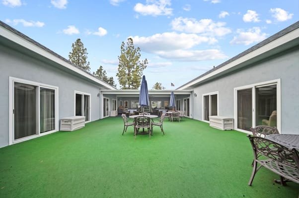 Outdoor seating area with green turf and umbrellas