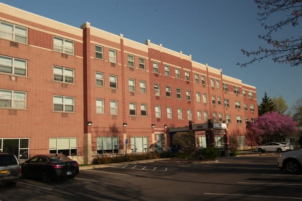 Exterior view of Barton Senior Residences with parking