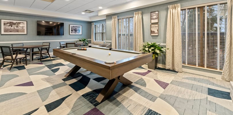 Activity room with a pool table and lounge seating