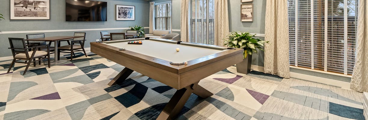 A bright activity room with a pool table