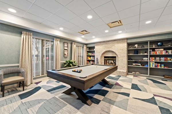 Bright common area with a pool table and bookshelves