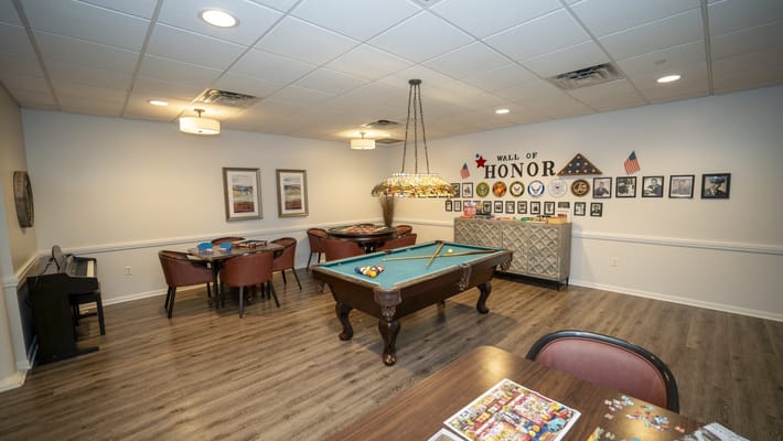 Interior common area with a billiards table and honor wall
