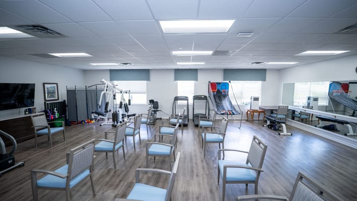 Interior activity room with exercise equipment and chairs