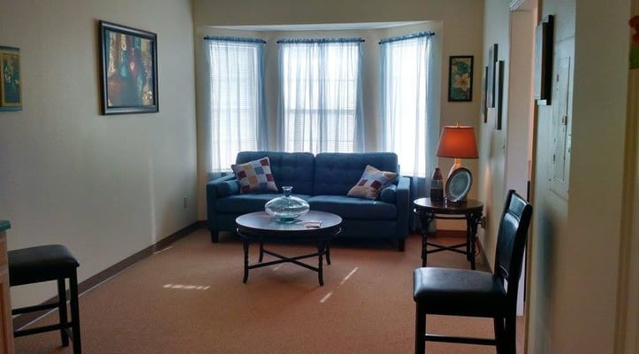 Comfortable living room with a blue sofa, coffee table, and lamp