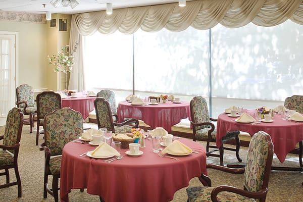Elegant dining room setup with red tablecloths and floral chairs
