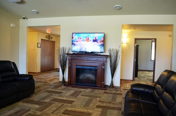 Common area with a fireplace and television