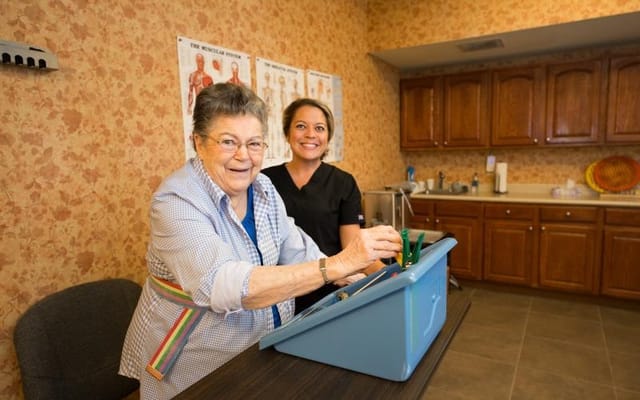 A resident and staff member engaging in an activity indoors
