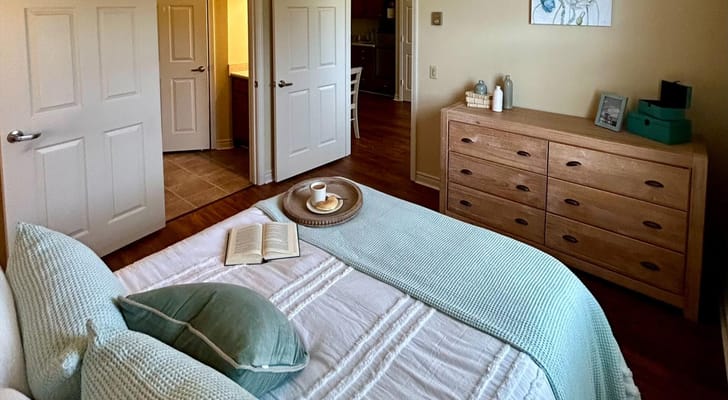A cozy bedroom with a book and tea tray