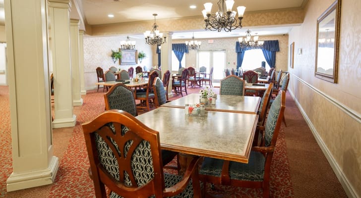 Bright dining room with tables and chairs arranged for residents