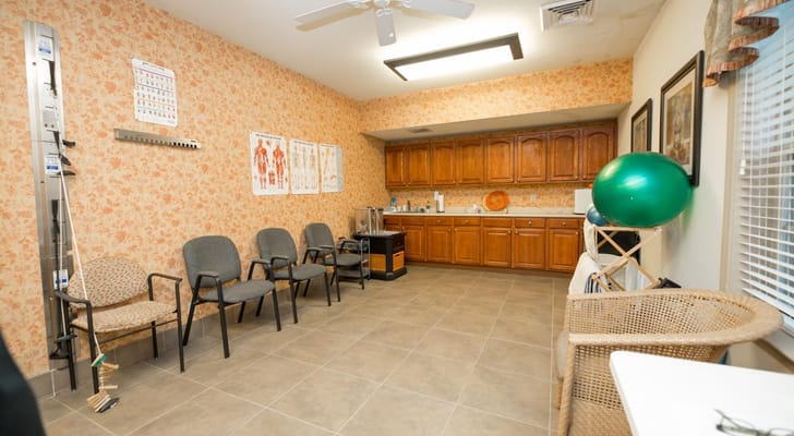Interior view of a waiting area with chairs and kitchen space