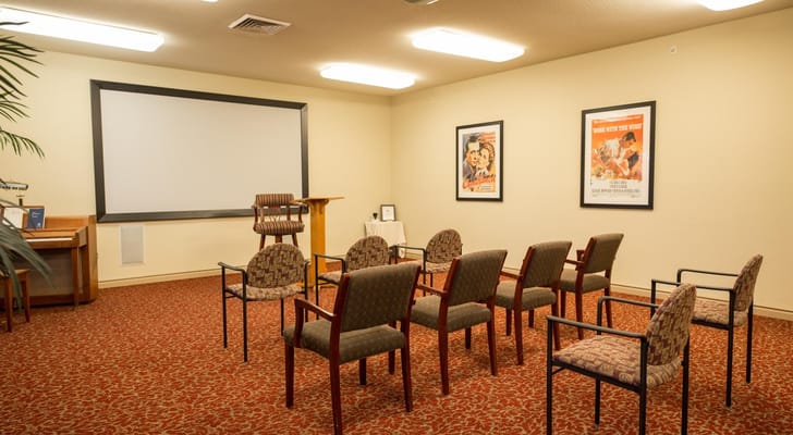 A common activity room with chairs and a projector