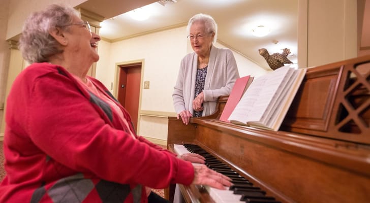 Residents enjoying music together at a piano