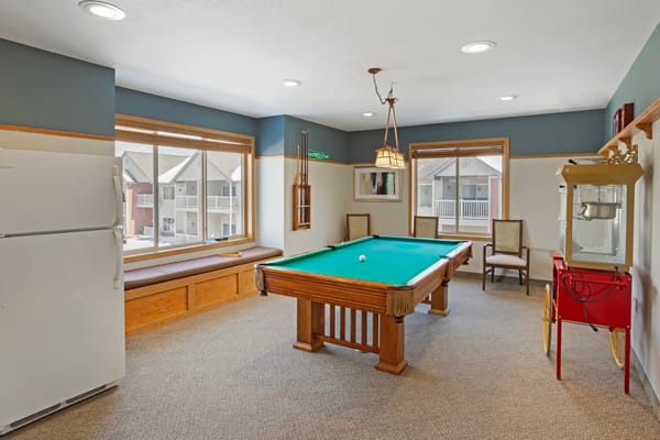 Interior view of the game room featuring a pool table and windows