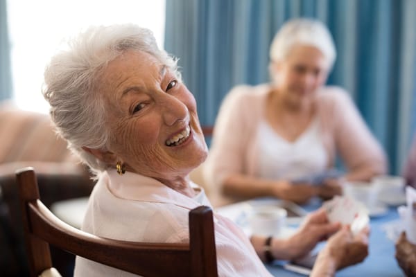 Residents enjoying a card game in a bright common area