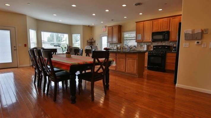 Bright dining area with a large table and kitchen