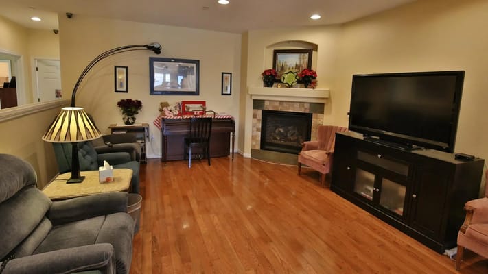 A cozy living room with comfortable seating, a fireplace, and a decorative workspace.