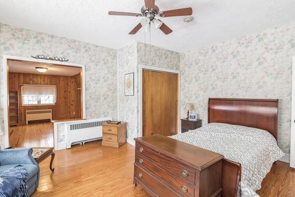 Private resident room with floral wallpaper and wooden furniture