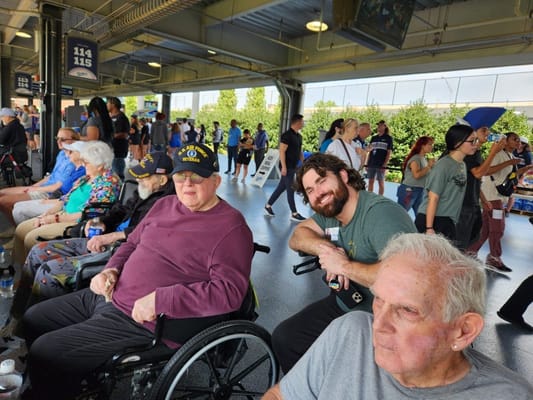 Seniors and staff gathered at an outdoor event, enjoying the atmosphere.
