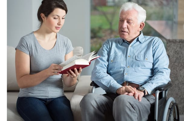 Resident and staff member reading together