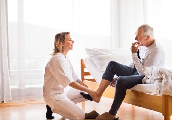 Caregiver assisting a senior in a bright bedroom