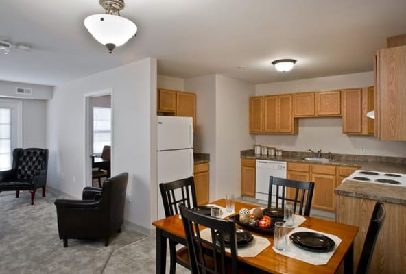 Modern kitchen with dining table and living area in Eagle Senior Village