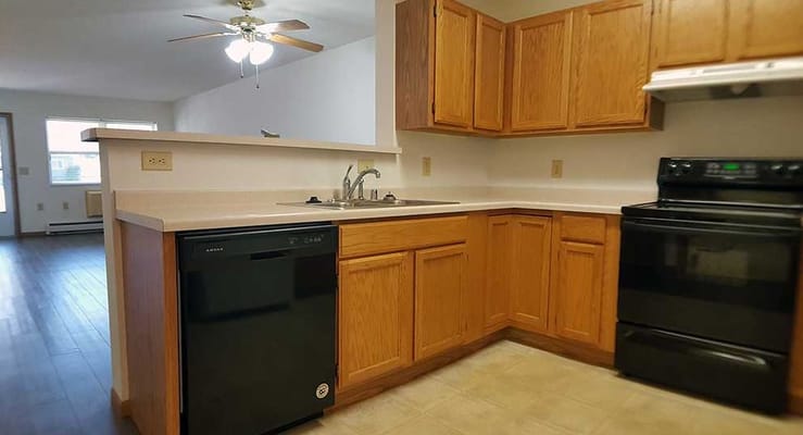 Spacious kitchen with wooden cabinets and appliances