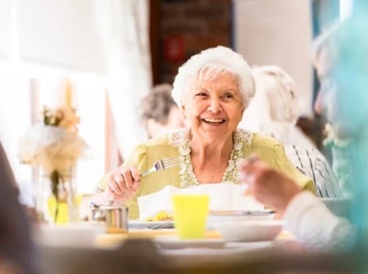 Resident enjoying a meal in a dining room