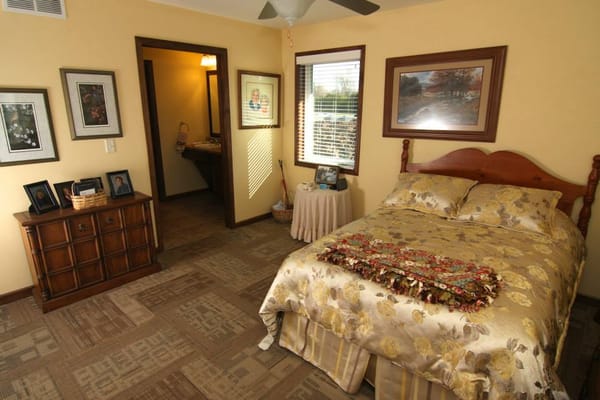 Cozy resident room with floral bedding and paintings