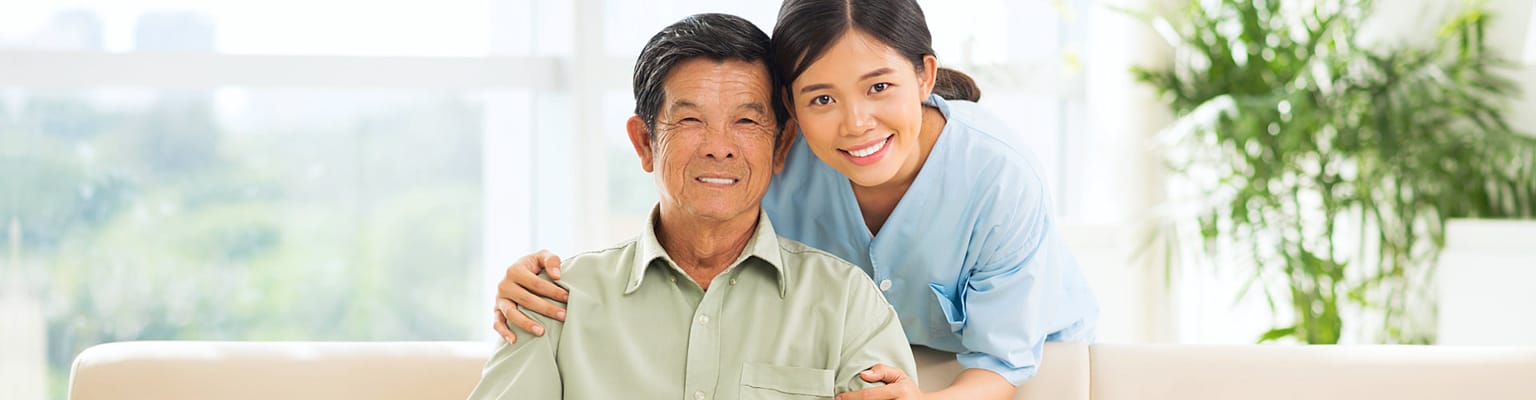 Caregiver and resident smiling together in a common area