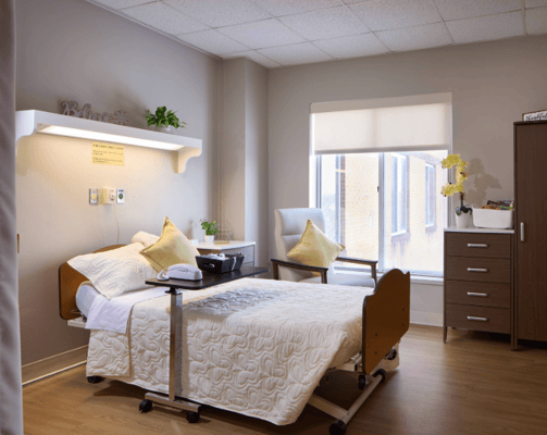 Bright, comfortable resident room with a bed and chair