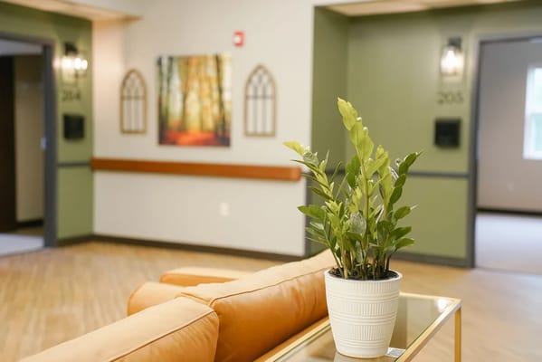 Interior view of a welcoming common area with plants and artwork