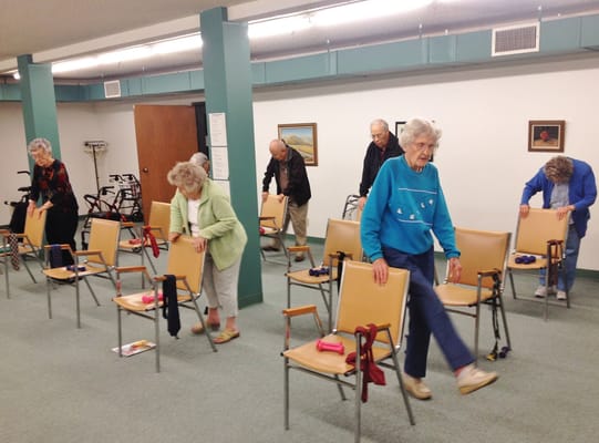 Residents participating in a seated exercise class