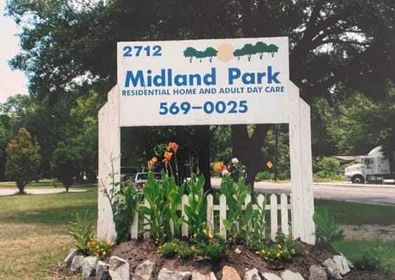 Sign for Midland Park Residential Home with flowers in front