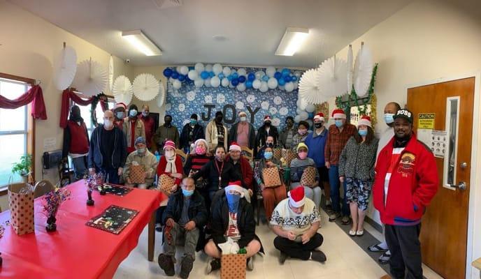 Residents celebrating a holiday event at Midland Park Residential Home wearing Santa hats.