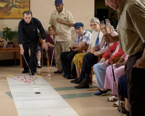 Residents participating in an indoor shuffleboard activity