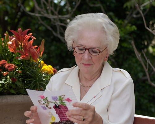 Resident outdoors enjoying crafts with flowers in background