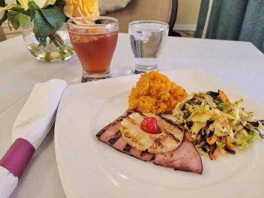 Plated meal with ham, pineapple, and vegetables
