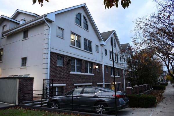 Exterior view of the Ateret Avot Senior Living building with a parked car