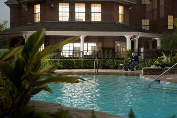 Resident enjoying the pool area at dusk