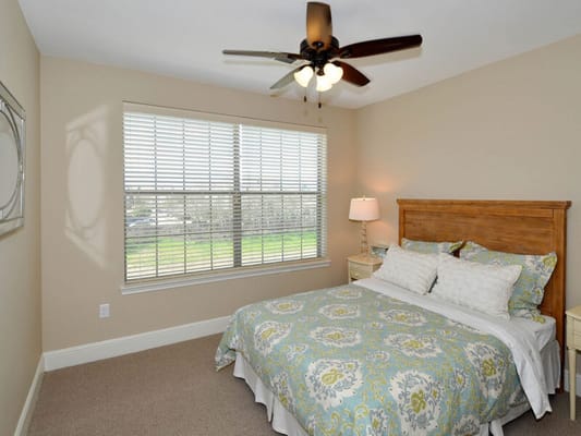Cozy bedroom with decorative bedding and a ceiling fan