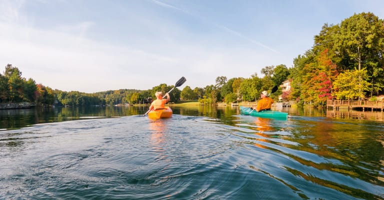 Two people kayaking on a serene lake